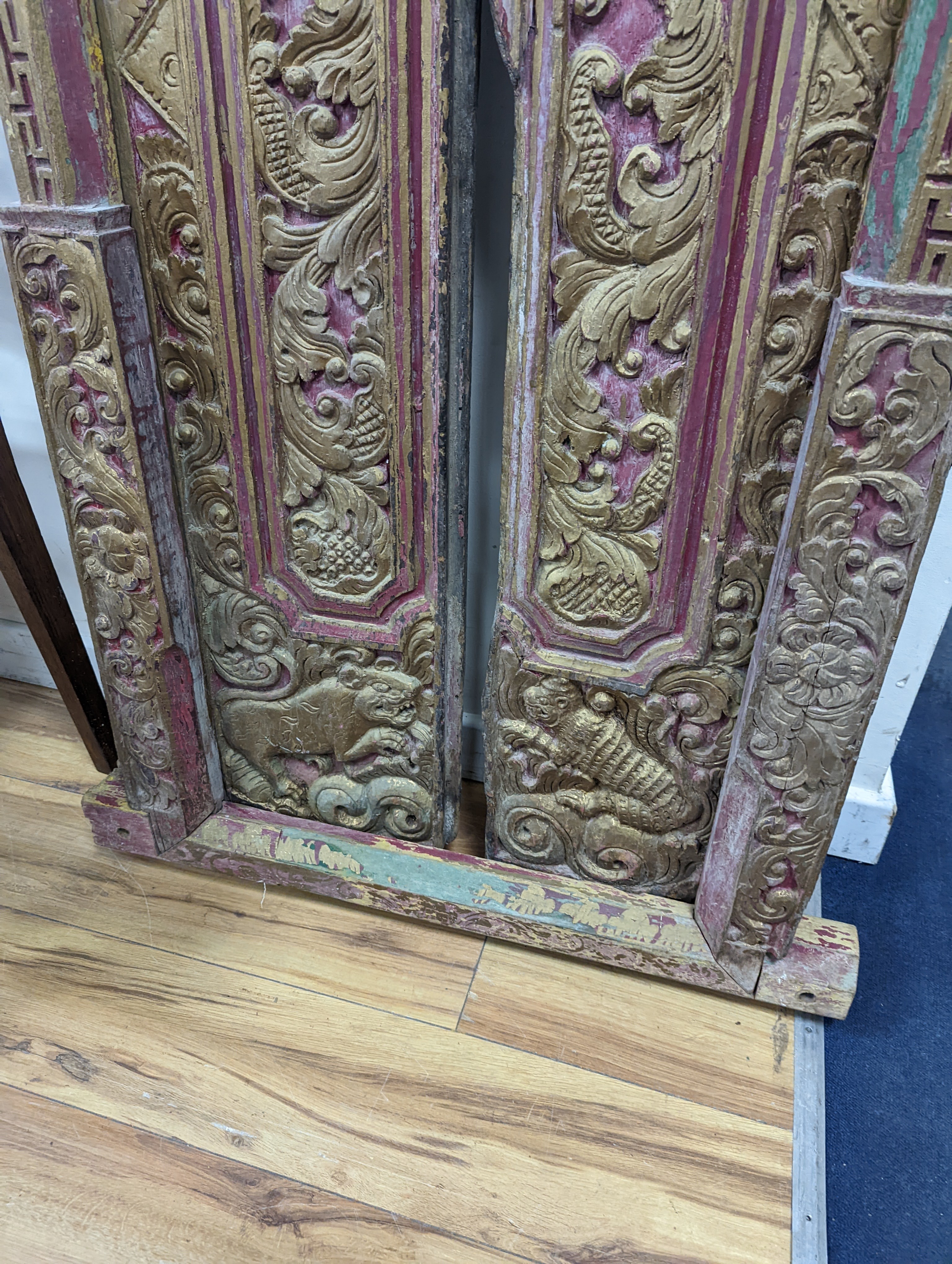 A Balinese carved giltwood door and frame, painted and gilded, width 83cm, height 174cm